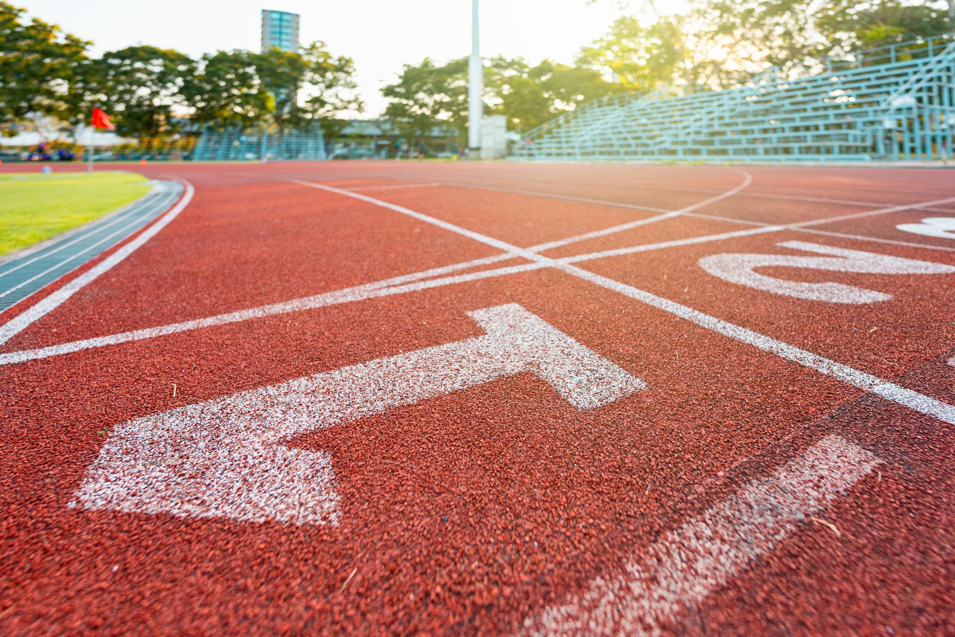 Running track with lane numbers and bleachers in the background. Running track with lane numbers and bleachers in the background.