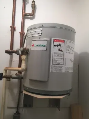 Gray water heater with pipes mounted in a utility closet