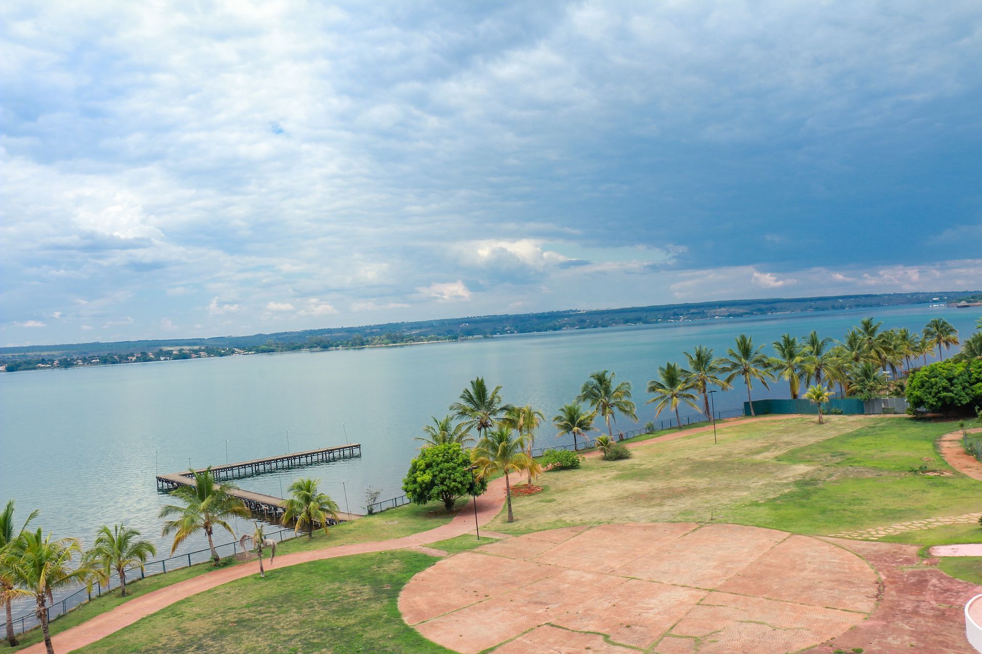 Um grande corpo de água cercado por palmeiras e grama. Bay Park Hotel