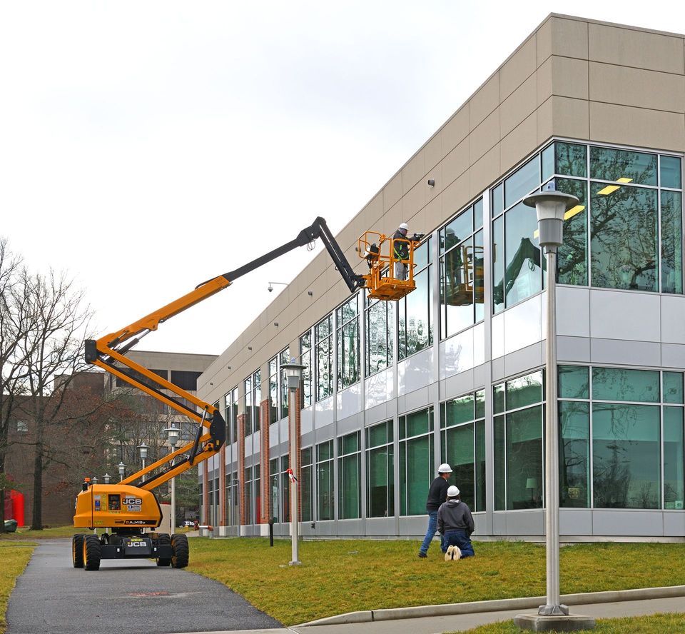 A man in a bucket is working on a building