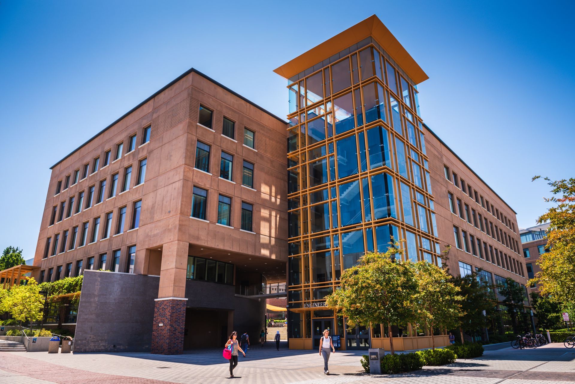 A large building with a lot of windows and people walking in front of it