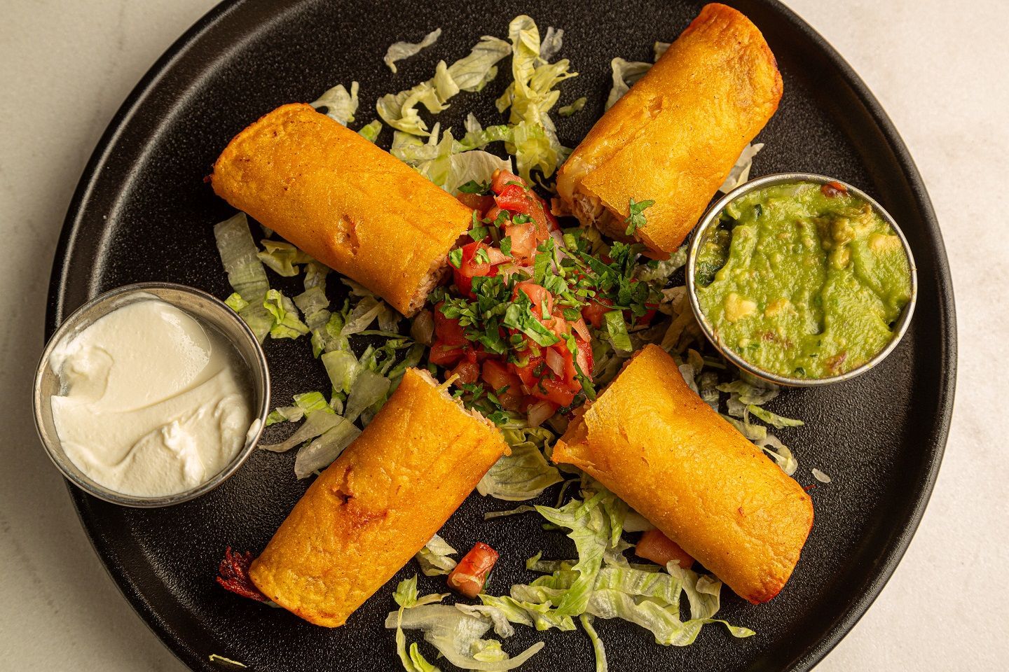 A plate of food with guacamole and sour cream on it.