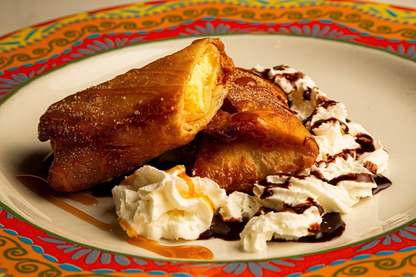 A plate of food with whipped cream and chocolate sauce on it