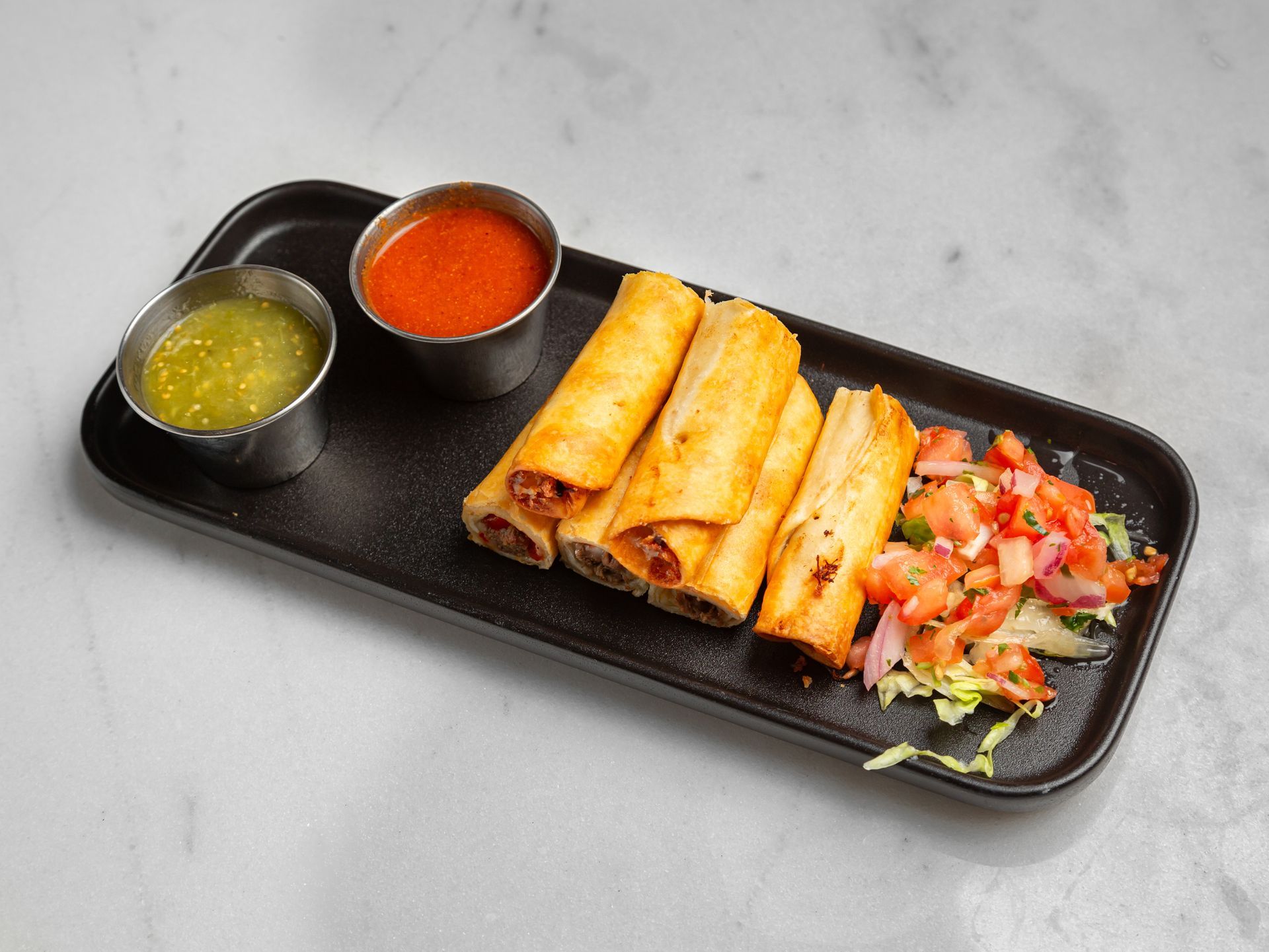 A plate of food with sauces and vegetables on a table.