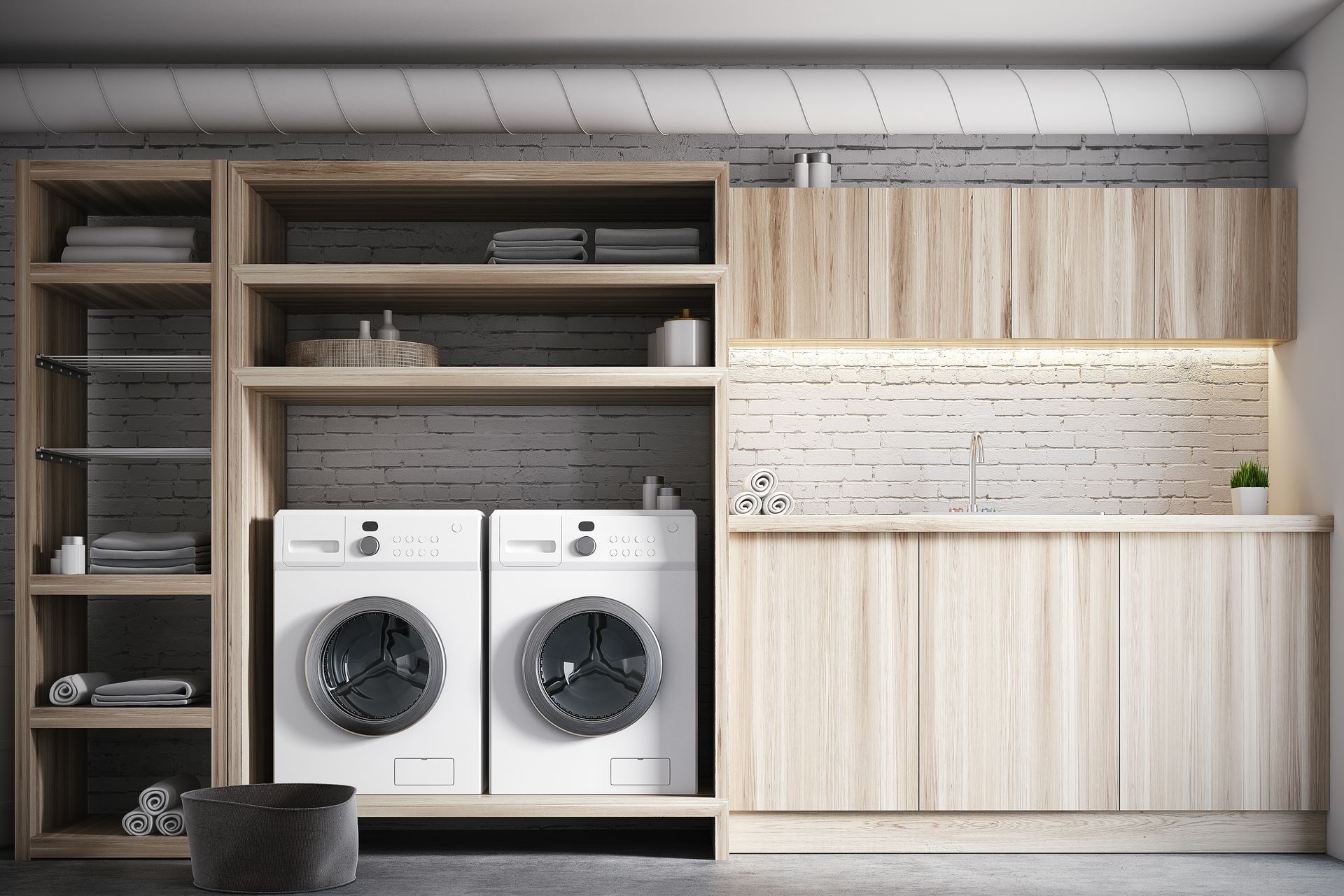 Modern laundry room with stacked shelves, two front-loading washers, and light wood cabinetry
