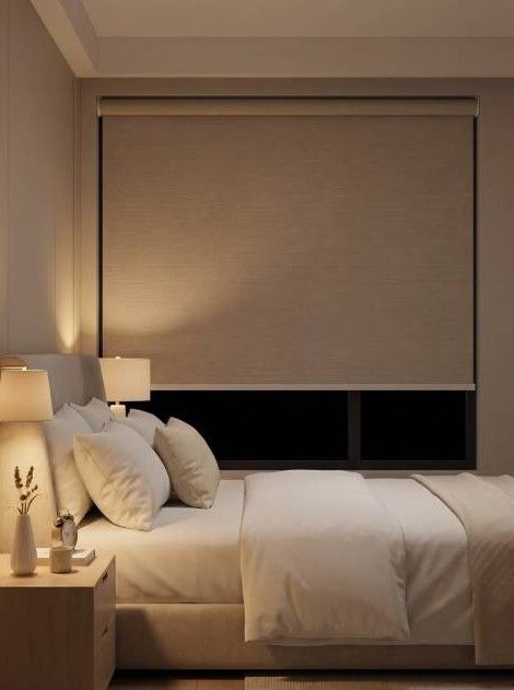 Dormitorio moderno de color beige con una cama bien hecha, lámparas de noche y una ventana con una persiana cerrada.
