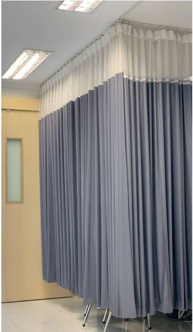 Pasillo del hospital con cortinas azules que dan privacidad y que cuelgan a lo largo de las paredes.