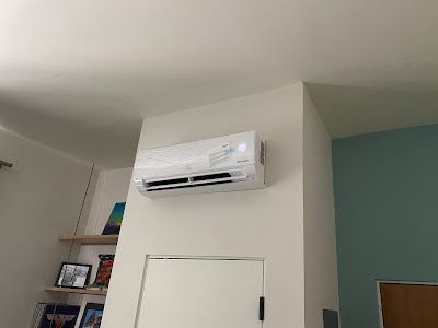 A room with a wall mounted air conditioner and a door.
