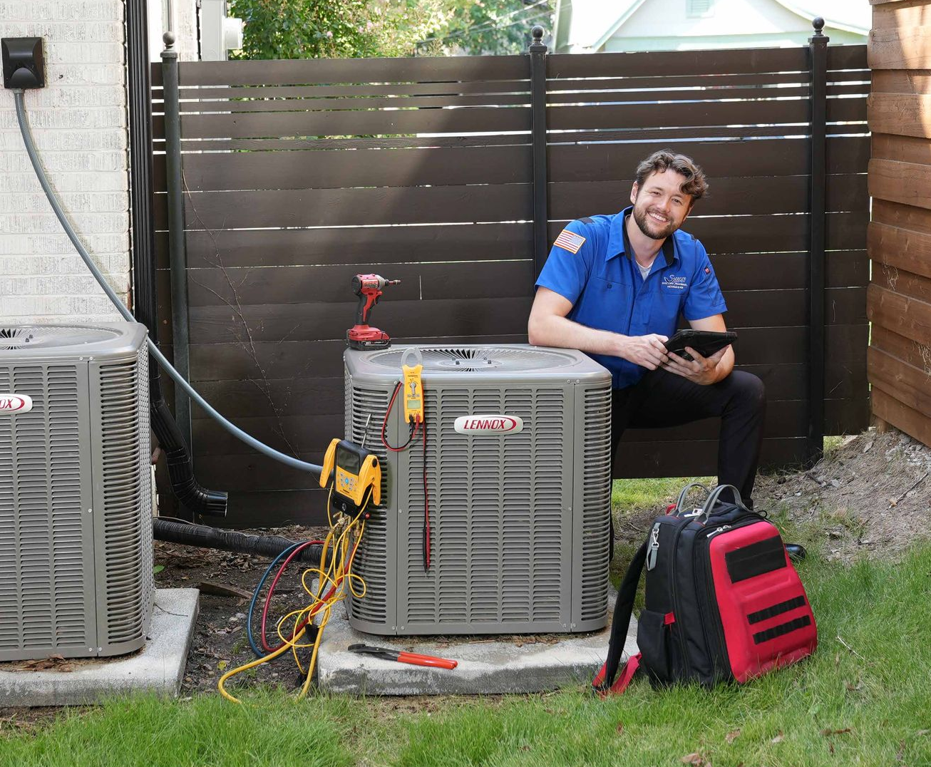 A man is working on an air conditioner outside of a house.