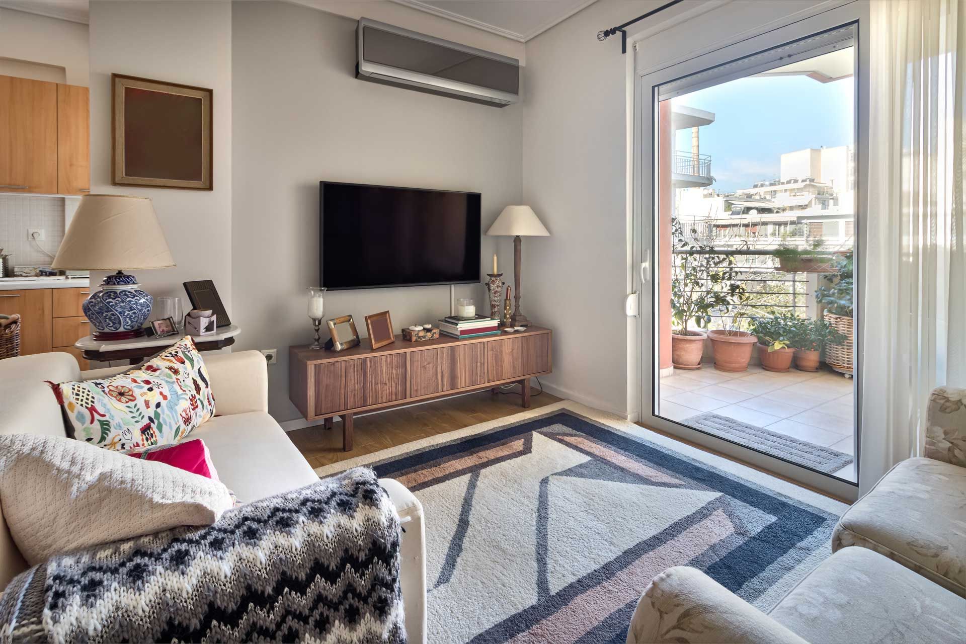A living room with a couch , chairs , and a flat screen tv.