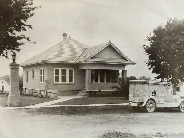 Vintage house with a truck parked in the driveway and trees in the yard