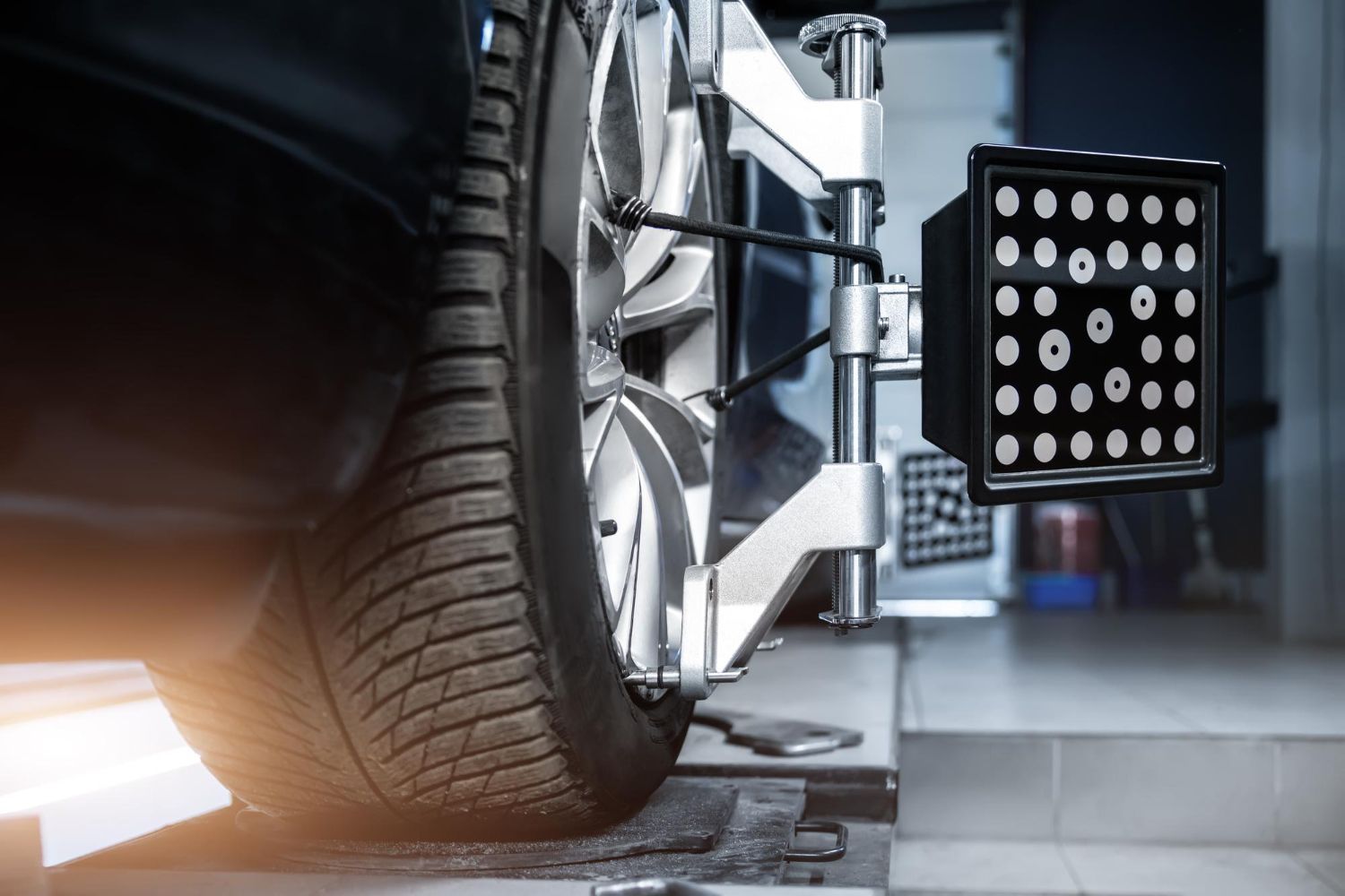 Close-up of a car tire and wheel alignment machine in an auto repair shop