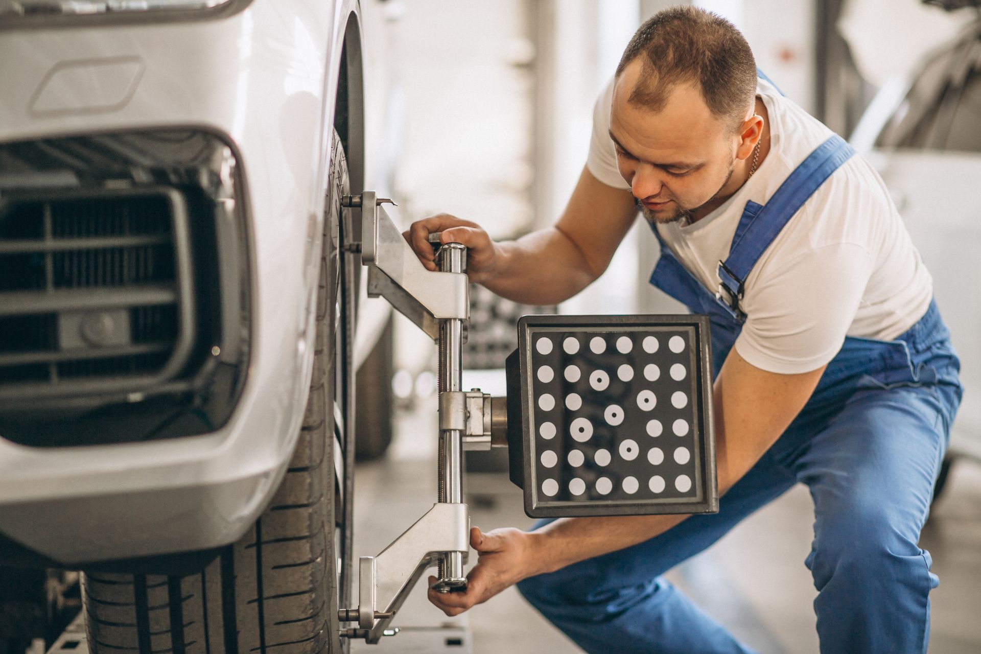 A man is working on a car wheel in a garage.