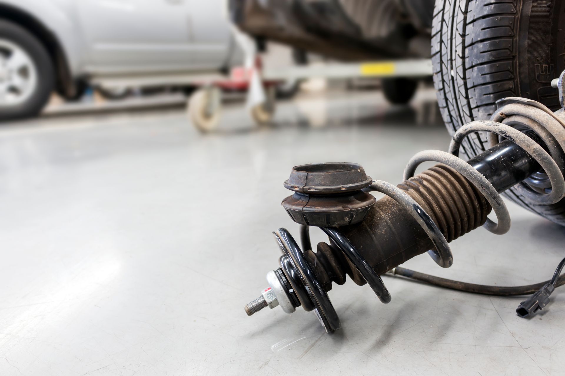 A close up of a car shock absorber in a garage.