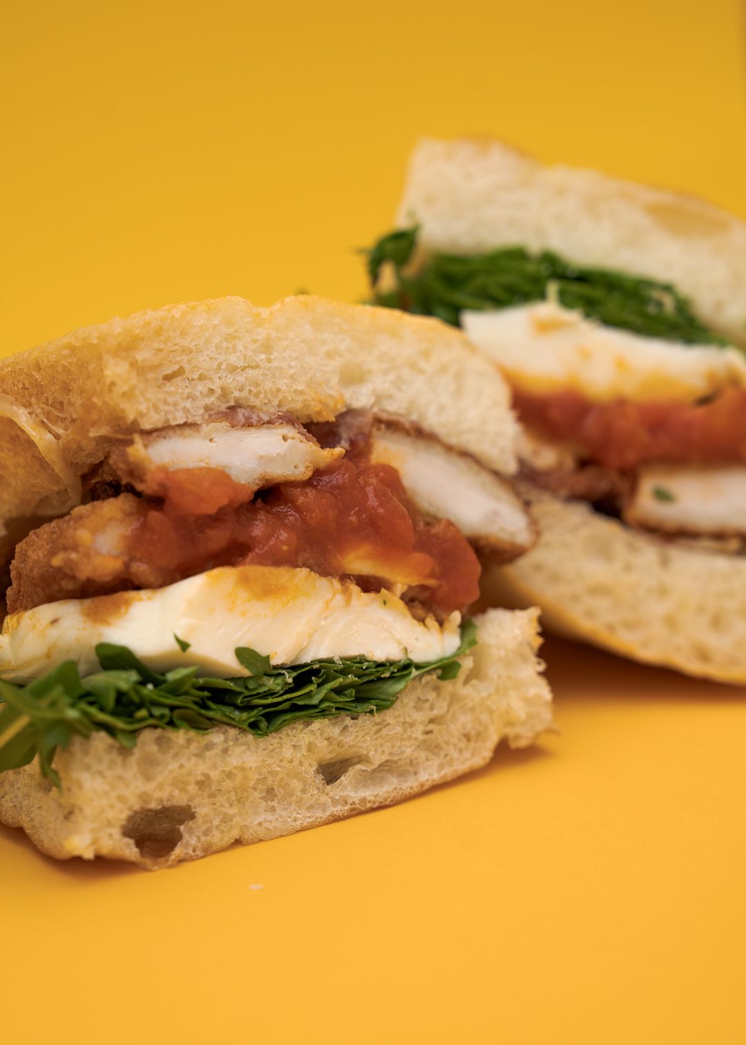 Hot Honey Parm sandwich on a mustard yellow background