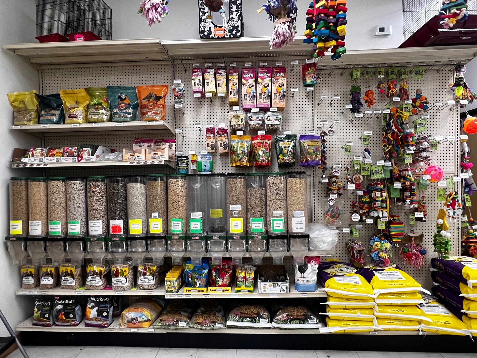 Animal House Pet & Supplies shelf packed with colorful packaged snacks, candy, and hanging trinkets.