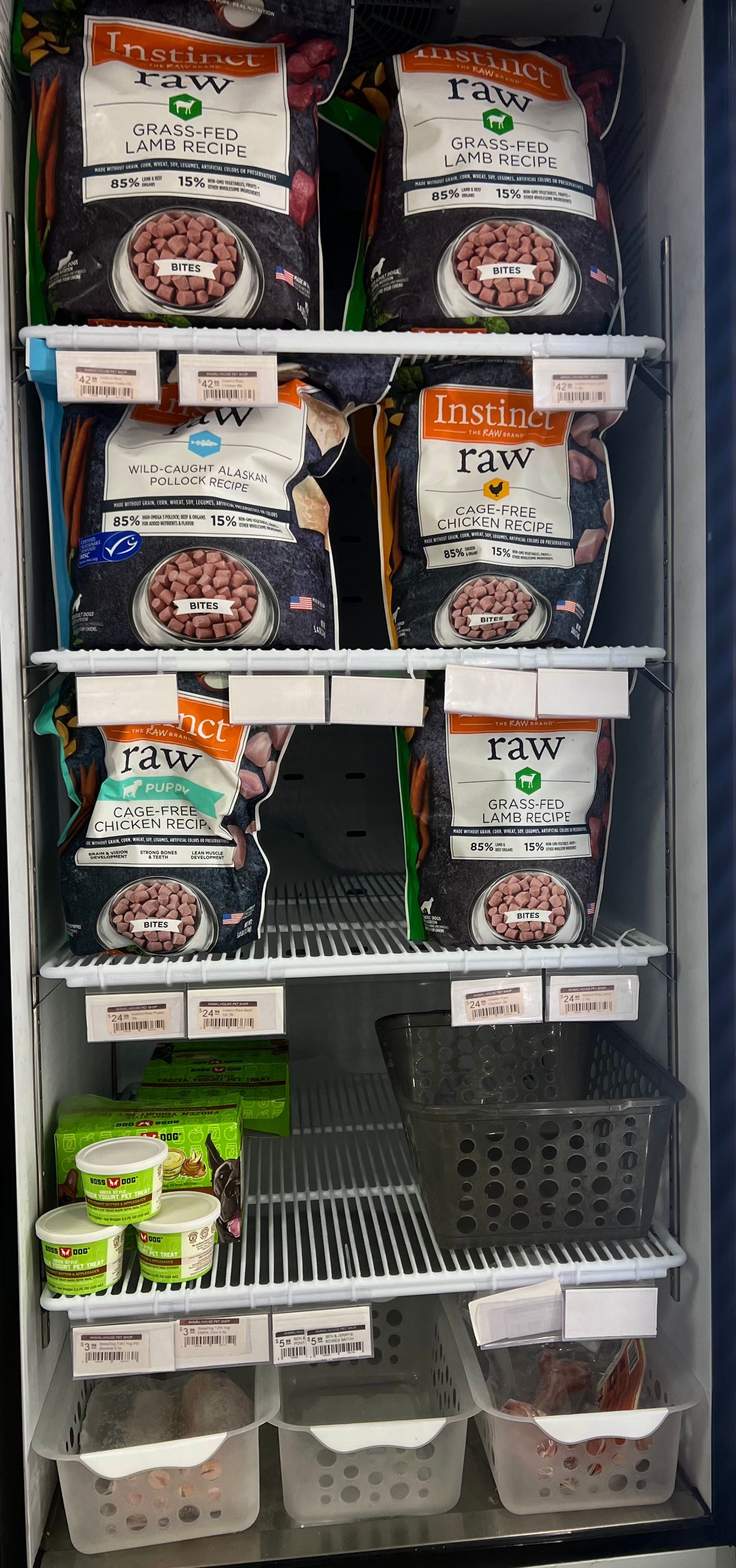 Animal House Pet & Supplies store shelf stocked with assorted packaged pet food and small containers in a retail aisle