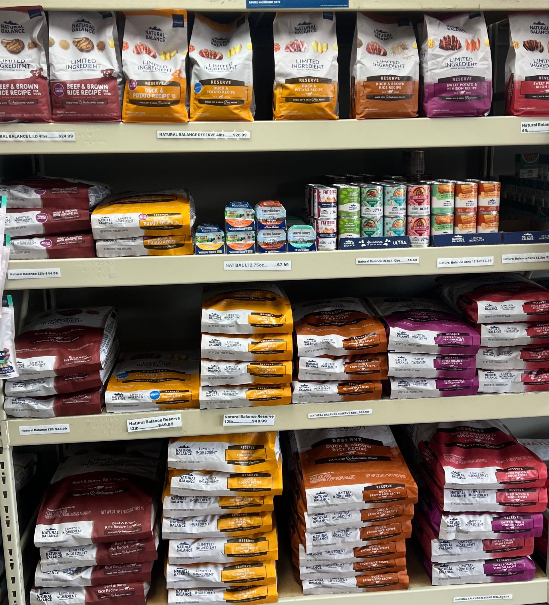 Animal House Pet & Supplies shelves stocked with neatly stacked packaged bread and baked goods in a grocery store aisle