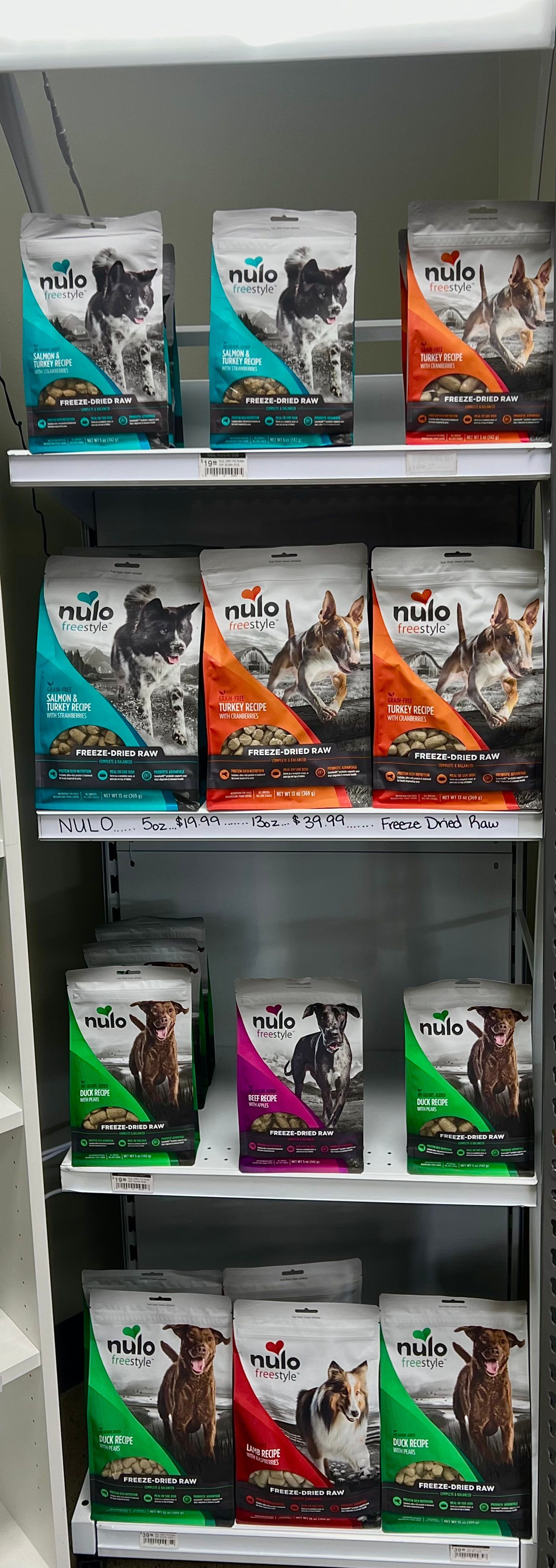 Animal House Pet & Supplies shelves of boxed toys or games in teal, orange, and green packaging in a store aisle