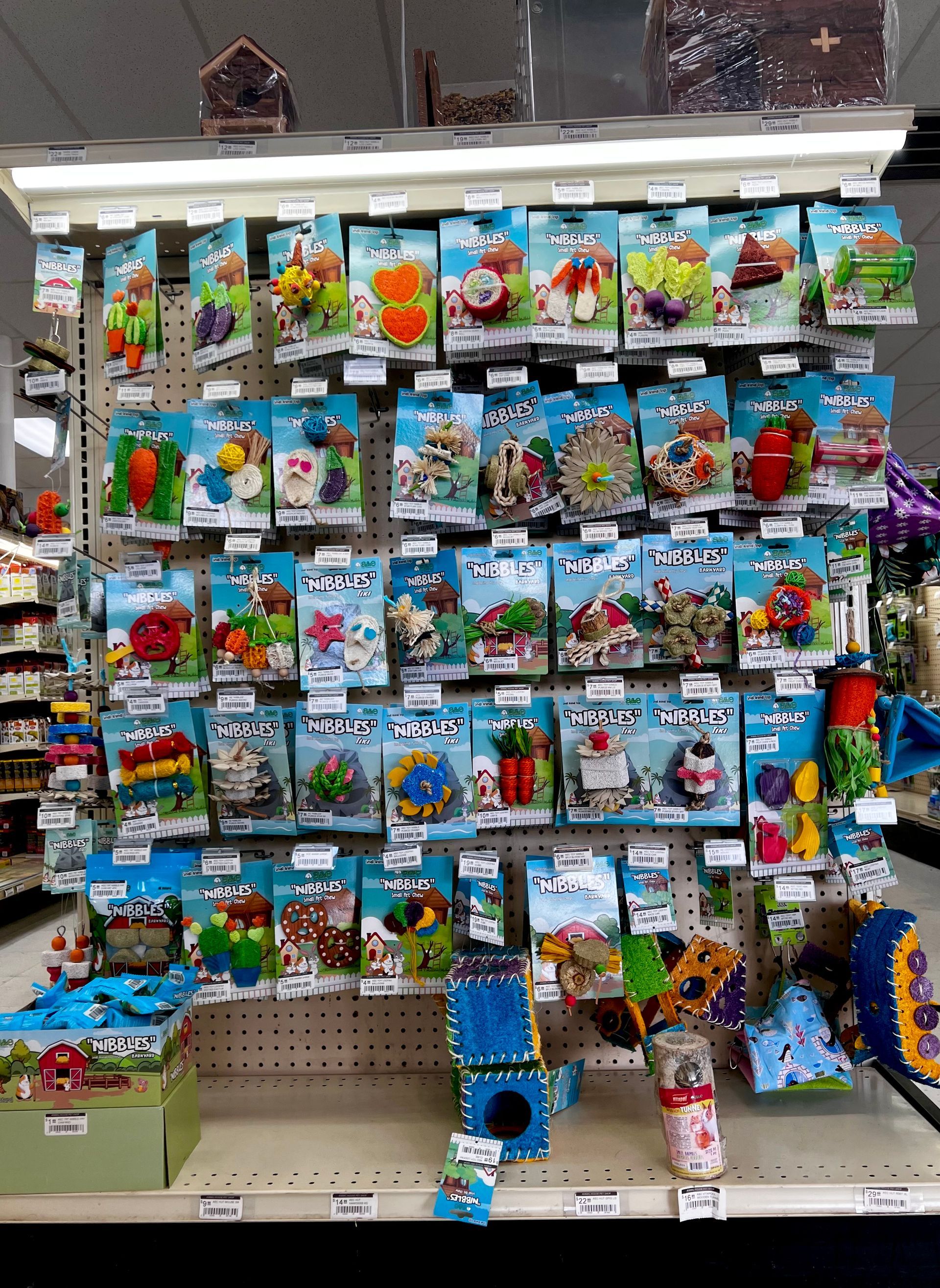 Animal House Pet & Supplies shelf packed with colorful small toys and novelty items in hanging display bags