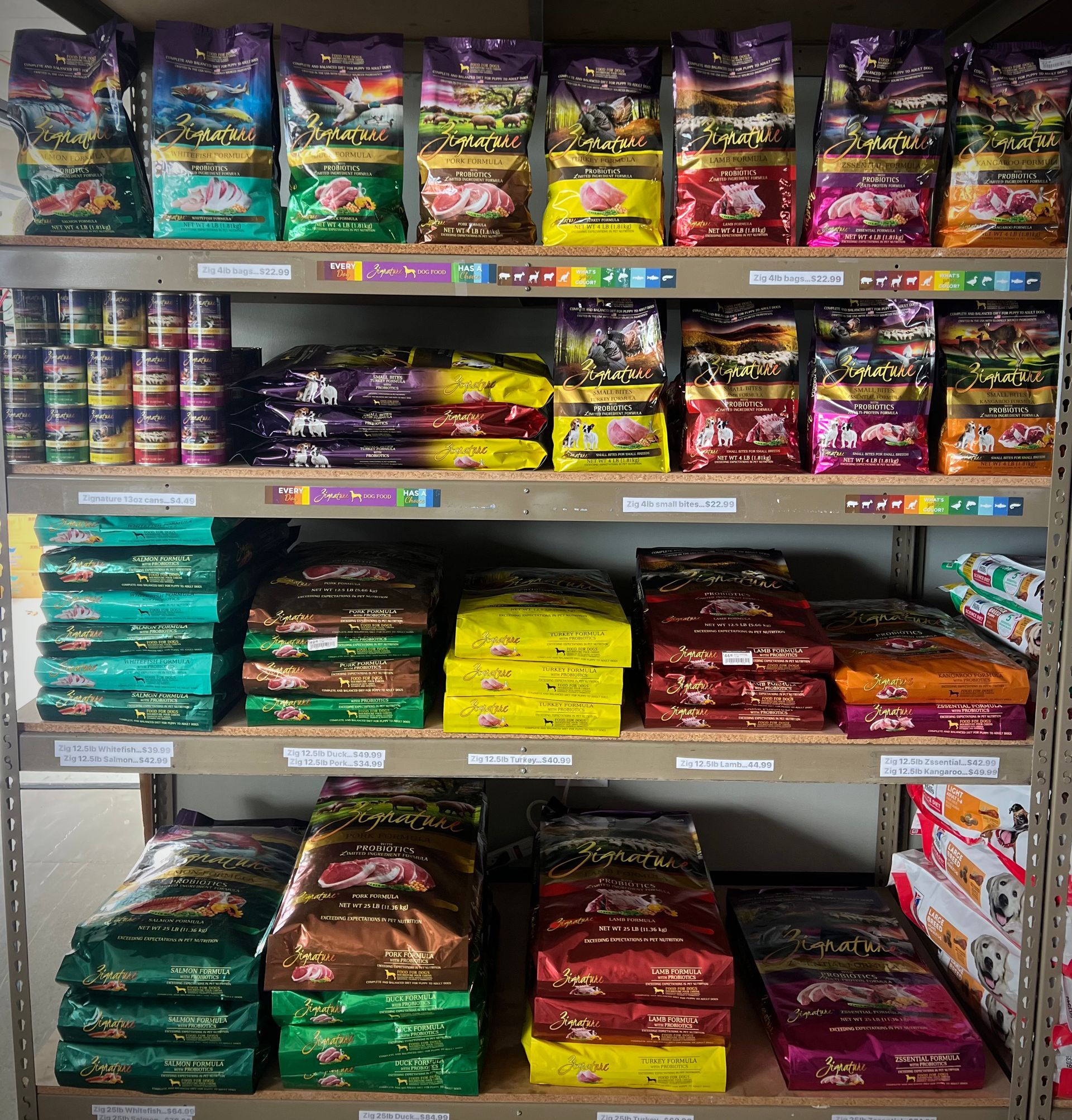 Animal House Pet & Supplies shelves of assorted colorful pet food bags and cans in a store aisle