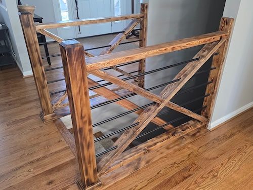 Wooden baby gate with diagonal slats blocking a hallway on hardwood floor