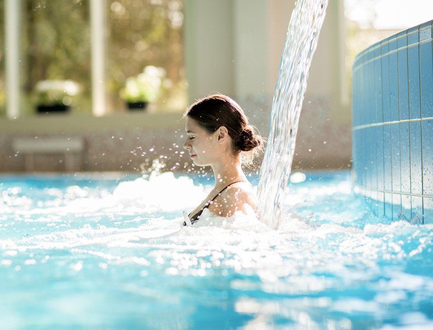 Girl Enjoying Stream Of Waterfall And Its Gentle Splashes In Swimming Pool And Spa — Nabiac Water Carriers In Belbora NSW