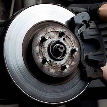 A person is fixing a brake disc on a car - Curry Truck & Auto