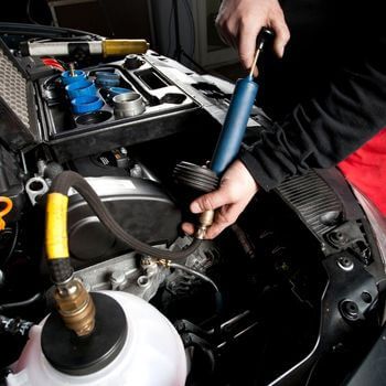 A person is working on the engine of a car - Curry Truck & Auto