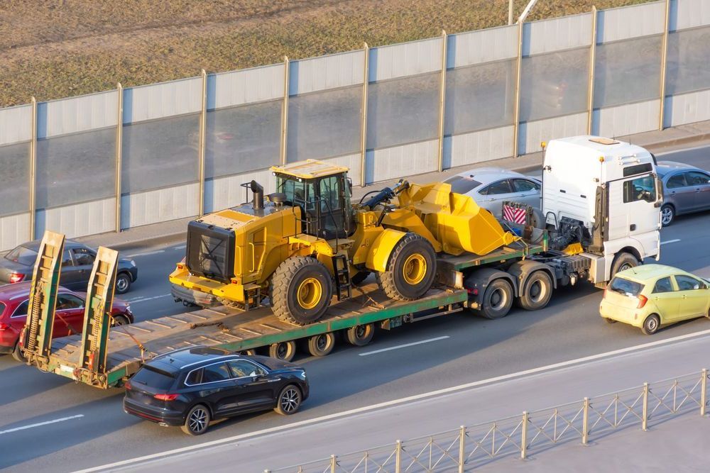 A Truck Is Carrying A Bulldozer On A Trailer On A Highway — Torquay & Anglesea Accident Towing Centre In Anglesea, VIC
