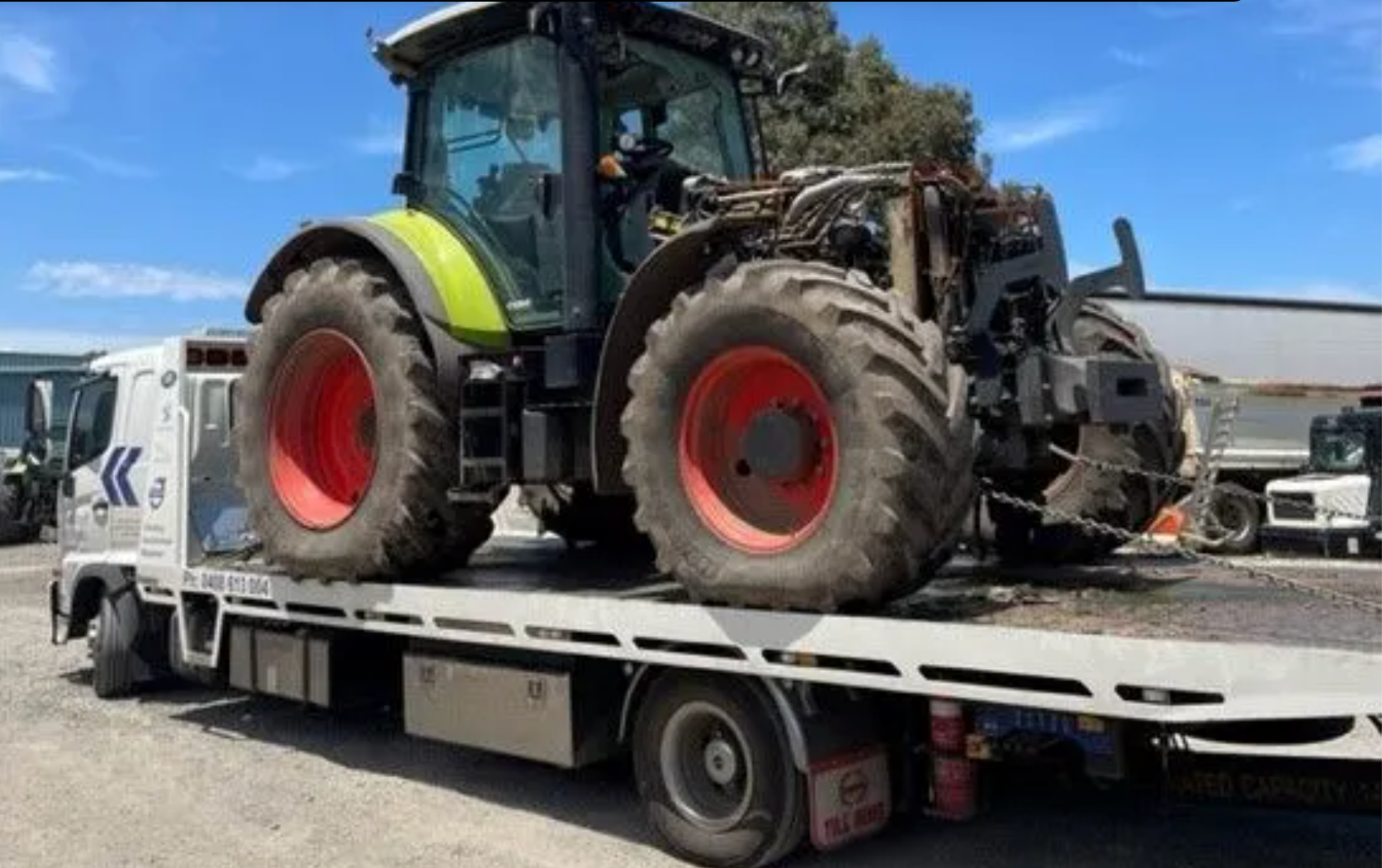 A Truck Is Carrying A Bulldozer On A Trailer On A Highway — Torquay & Anglesea Accident Towing Centre In Torquay, VIC