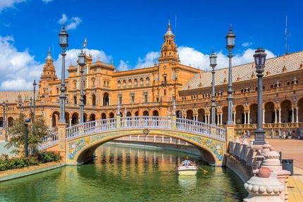 A bridge over a body of water in front of a large building.