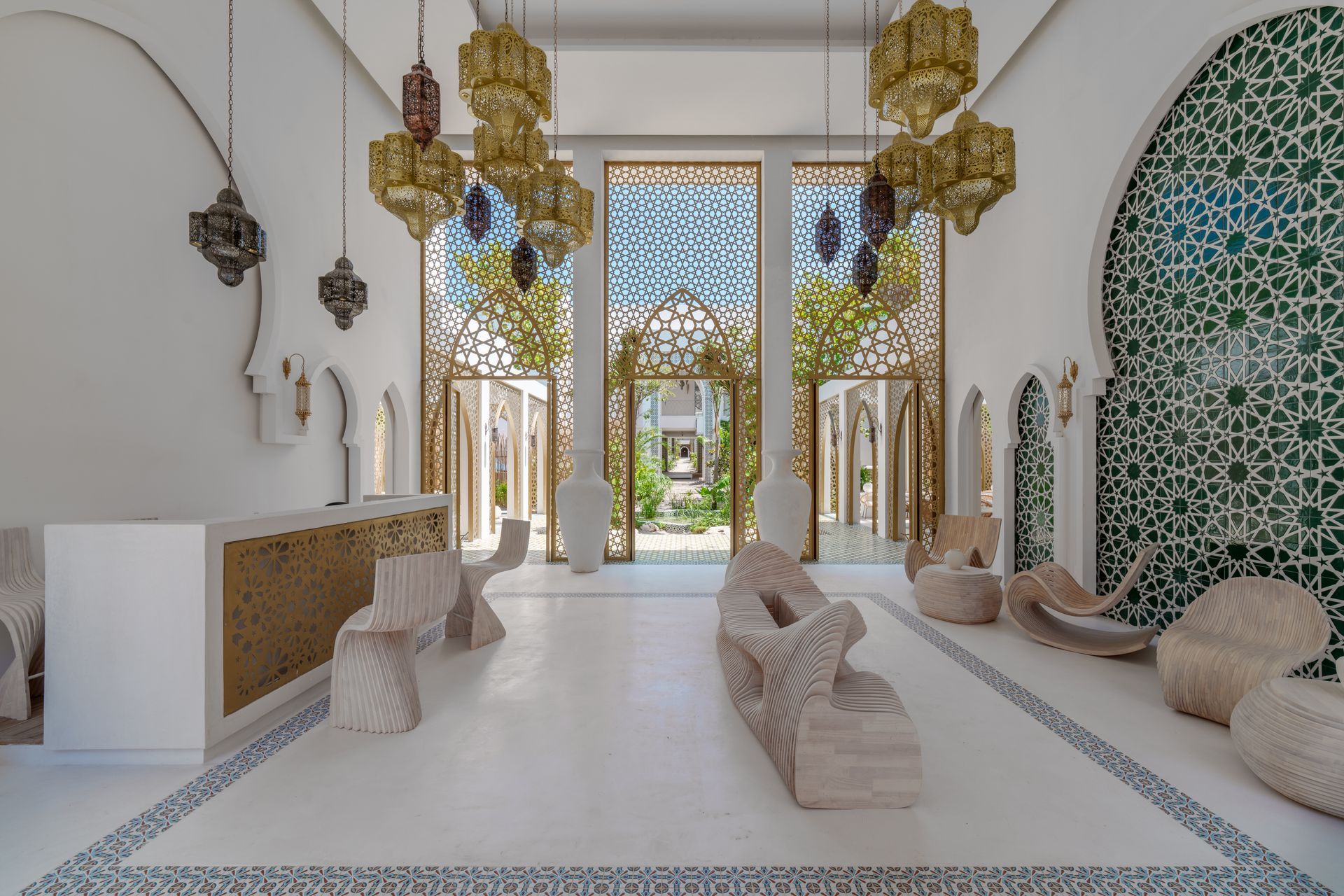 Interior luminoso y ornamentado con paredes blancas, detalles dorados y azulejos estampados. Cuenta con asientos, faroles y vistas a un espacio exterior.