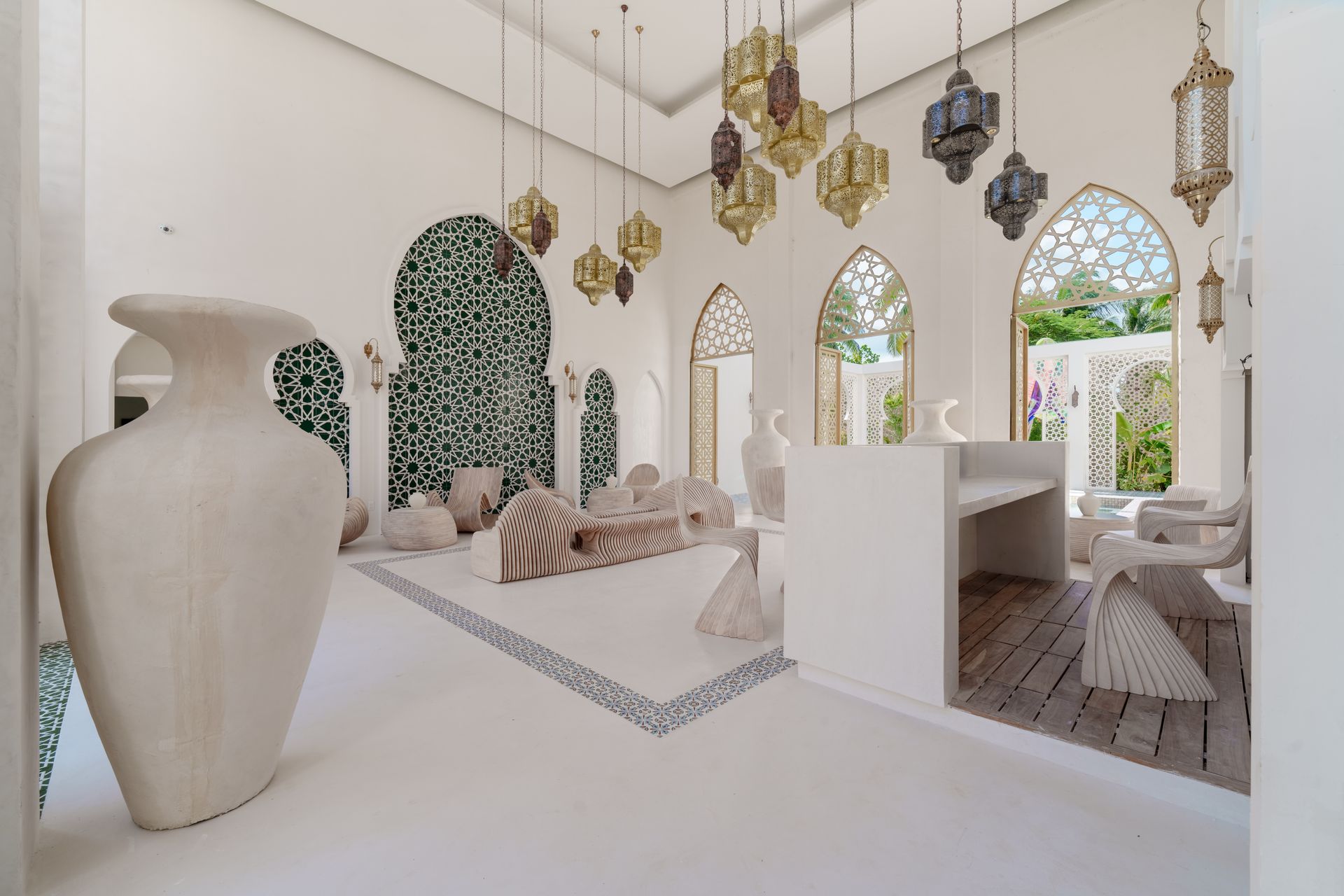 Habitación blanca con ventanas arqueadas, faroles decorativos y alfombra estampada.