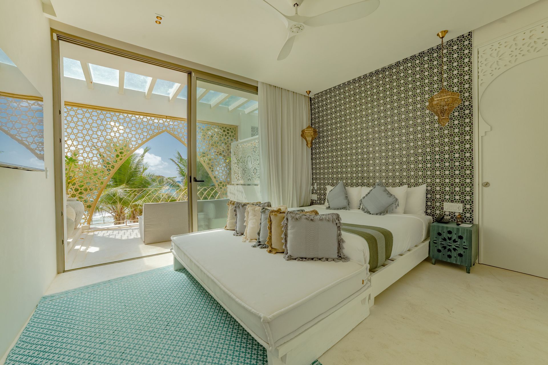 Dormitorio con decoración en blanco y turquesa, con cama y vista a un espacio exterior.
