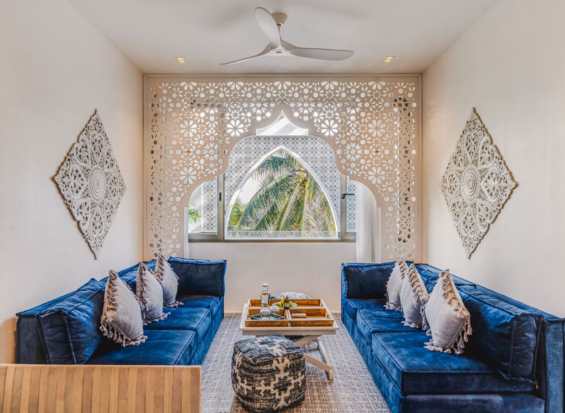 Living room with blue sofas, ornate white arch over window, mountain view.