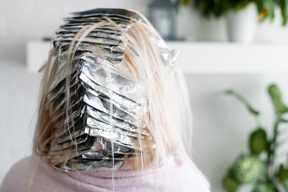 A Woman is Getting Her Hair Dyed With Aluminum Foil — Losh Hair Lounge In Toowoomba City, QLD