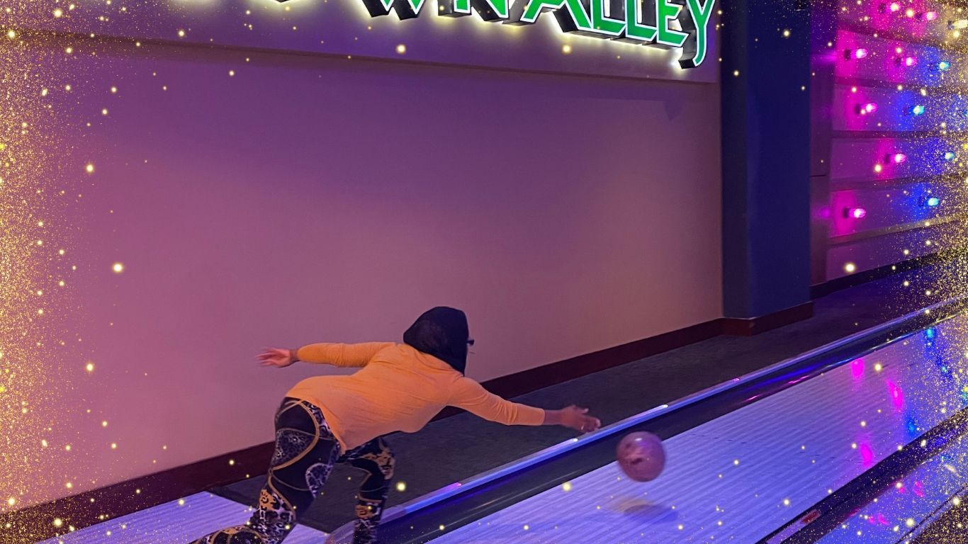 A person is throwing a bowling ball on a bowling alley.