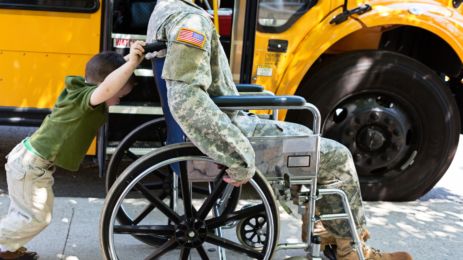 A woman in a wheelchair is sitting in front of an american flag.