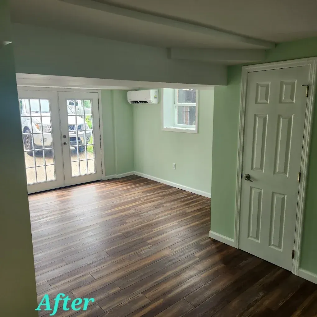 Empty room with dark wood floors, pale green walls, and French doors labeled “After.”