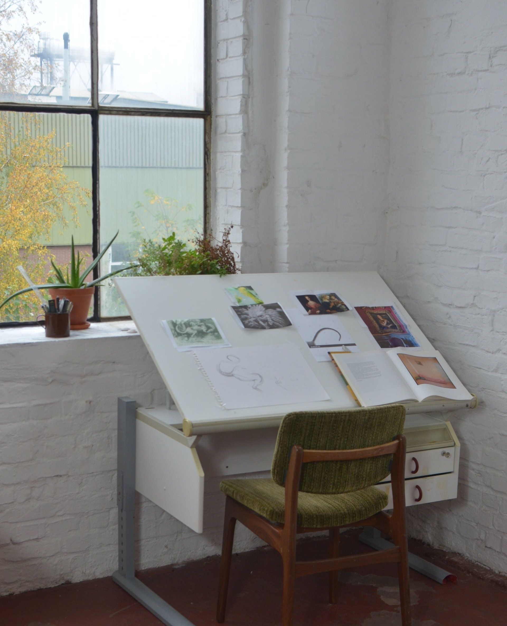 une chaise verte est assise à côté d' un bureau blanc