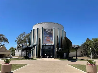 HWH San Diego Hard Money Lender - Real Estate highlights innovation and opportunity near landmarks like the San Diego Air & Space Museum. The image features historic aircraft, space exhibits, and striking architecture that symbolize exploration and progress.