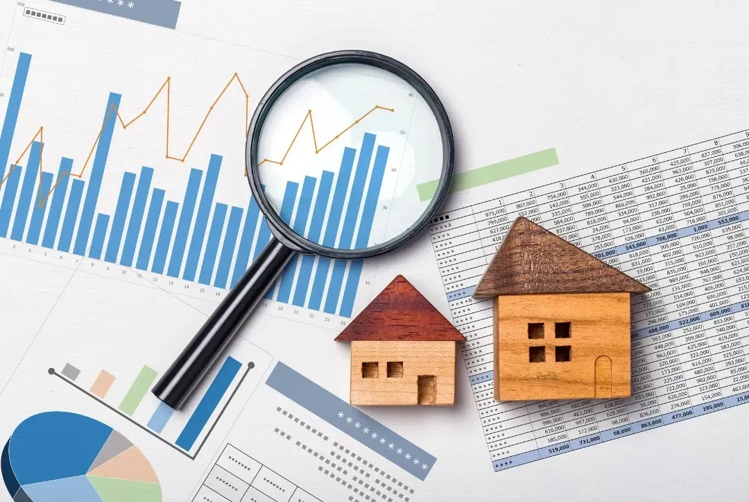 HWH San Diego Hard Money Lender - Real Estate displays a magnifying glass placed on a worksheet with a small wooden house beside it, symbolizing detailed property analysis.