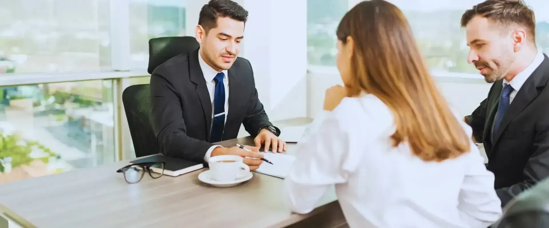 HWH San Diego Hard Money Lender - Real Estate shows a professional man in a suit and tie talking with his client in an office setting.