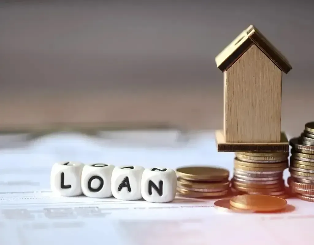 San Diego Hard Money Lender - The image shows a wooden house on stacked coins, symbolizing property investment, with