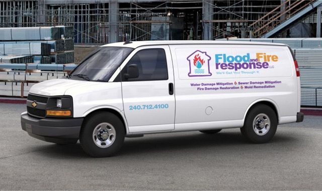 White Flood Fire Response van parked outdoors, with colorful company logo on the side.