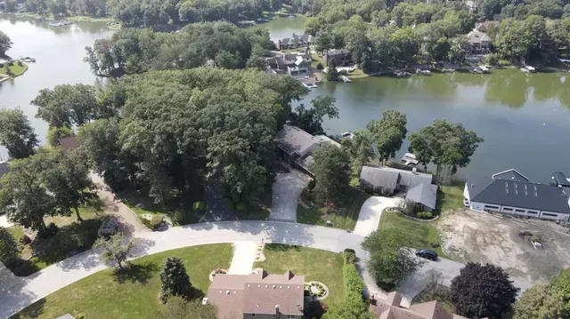 An aerial view of a lake surrounded by houses and trees