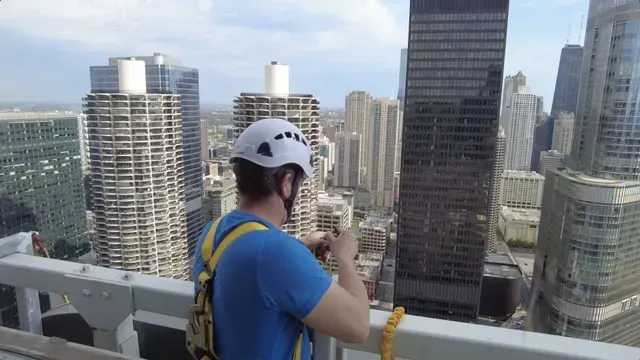 A man wearing a helmet stands on a bridge overlooking a city