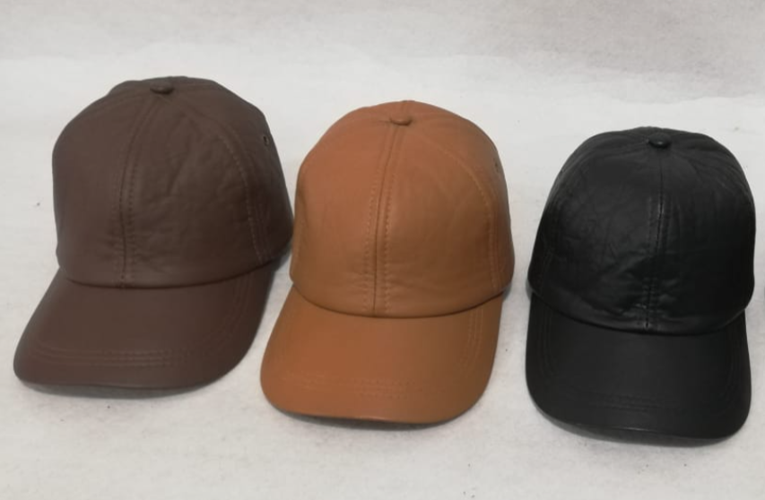 Tres gorras de béisbol en color marrón, beige y negro sobre una superficie blanca.