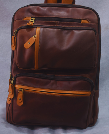 Mochila de cuero marrón con dos bolsillos delanteros con cremallera y tiradores de cremallera color canela.